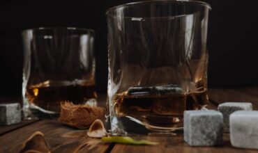 Due bicchieri di whisky vicino a qualche whisky stone