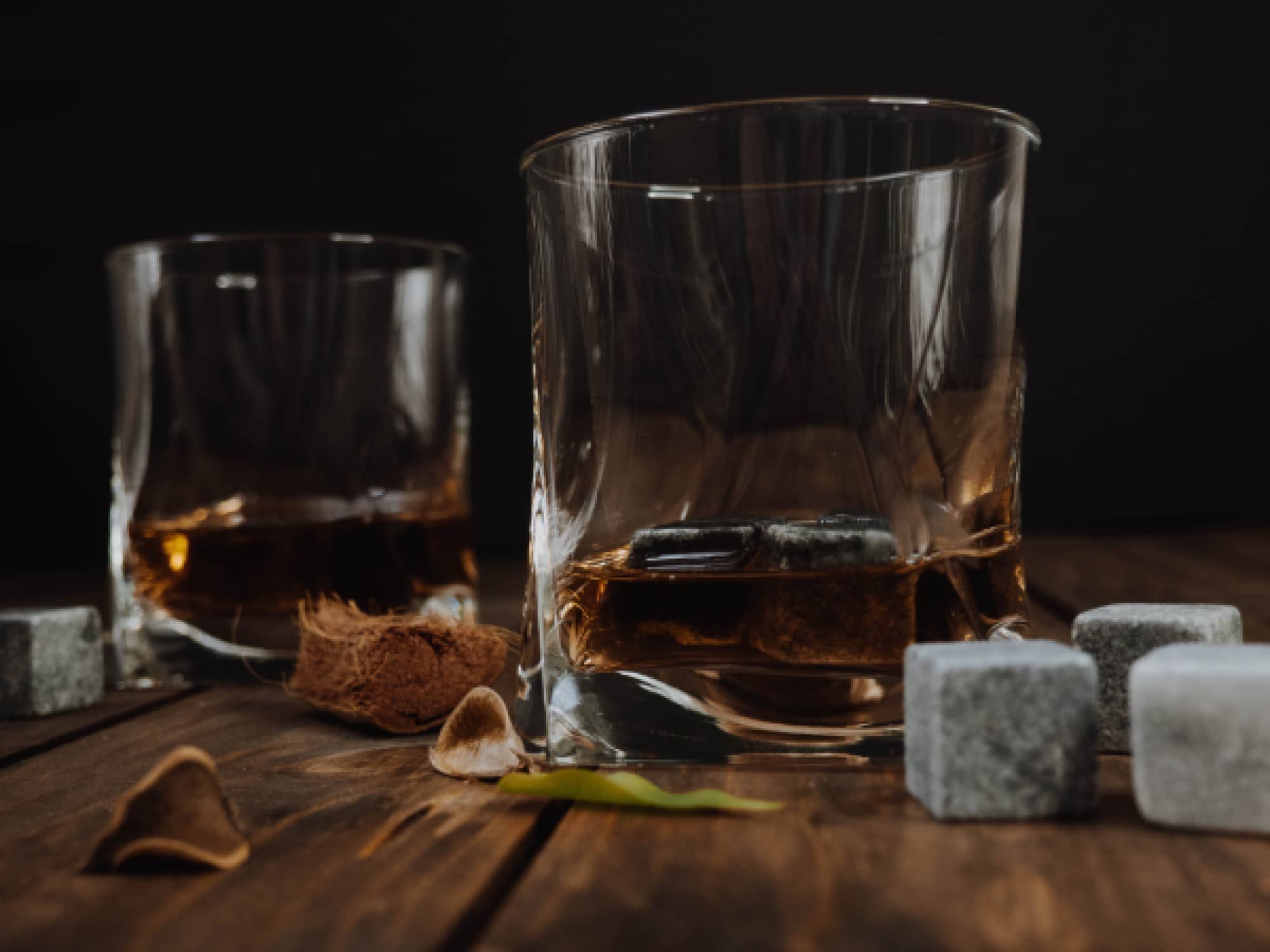 Due bicchieri di whisky vicino a qualche whisky stone